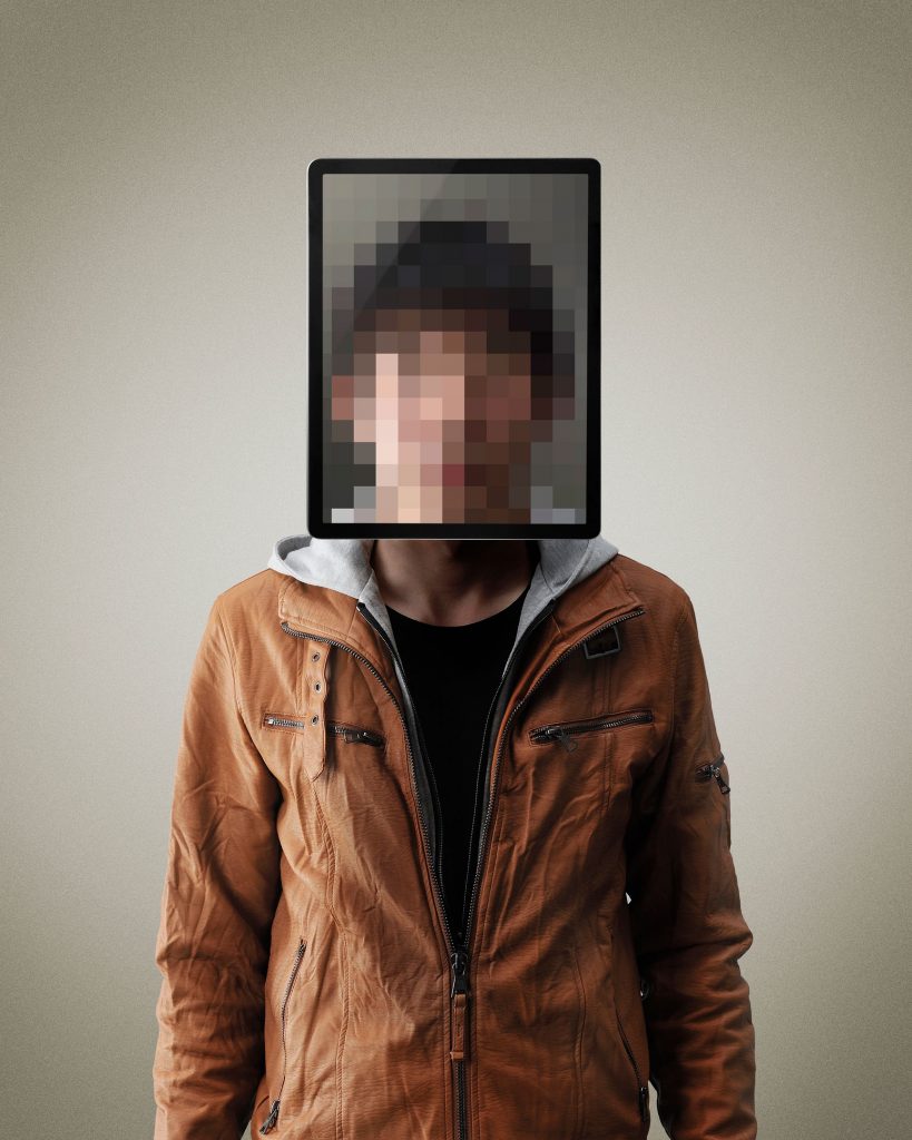 A male standing with his face pixelated out by a computing device.