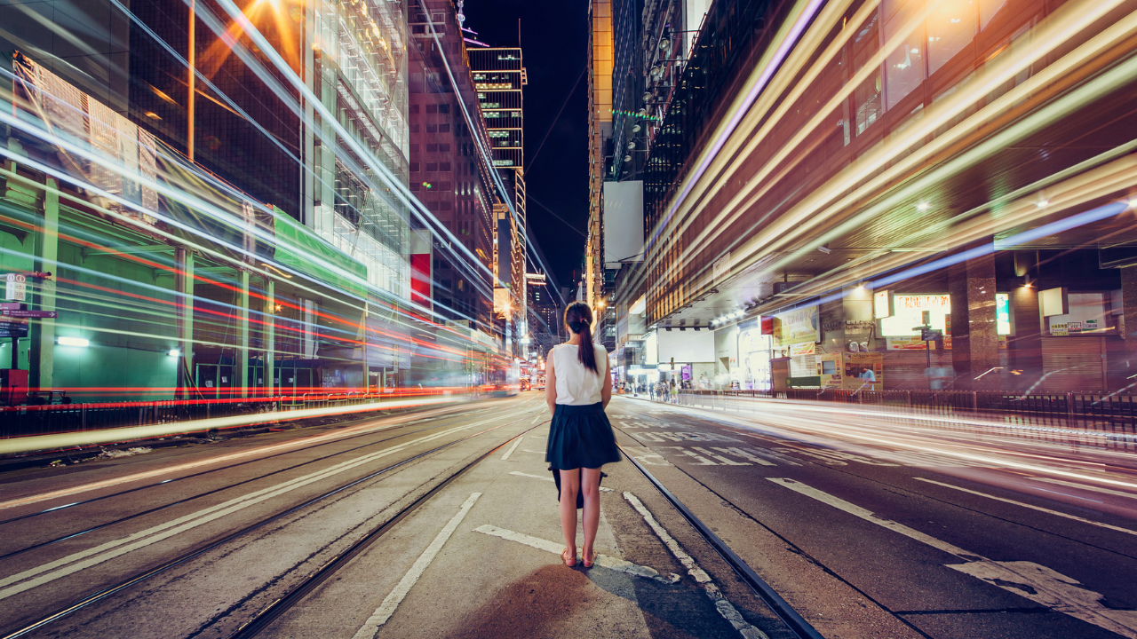 Woman standing in city street with lights