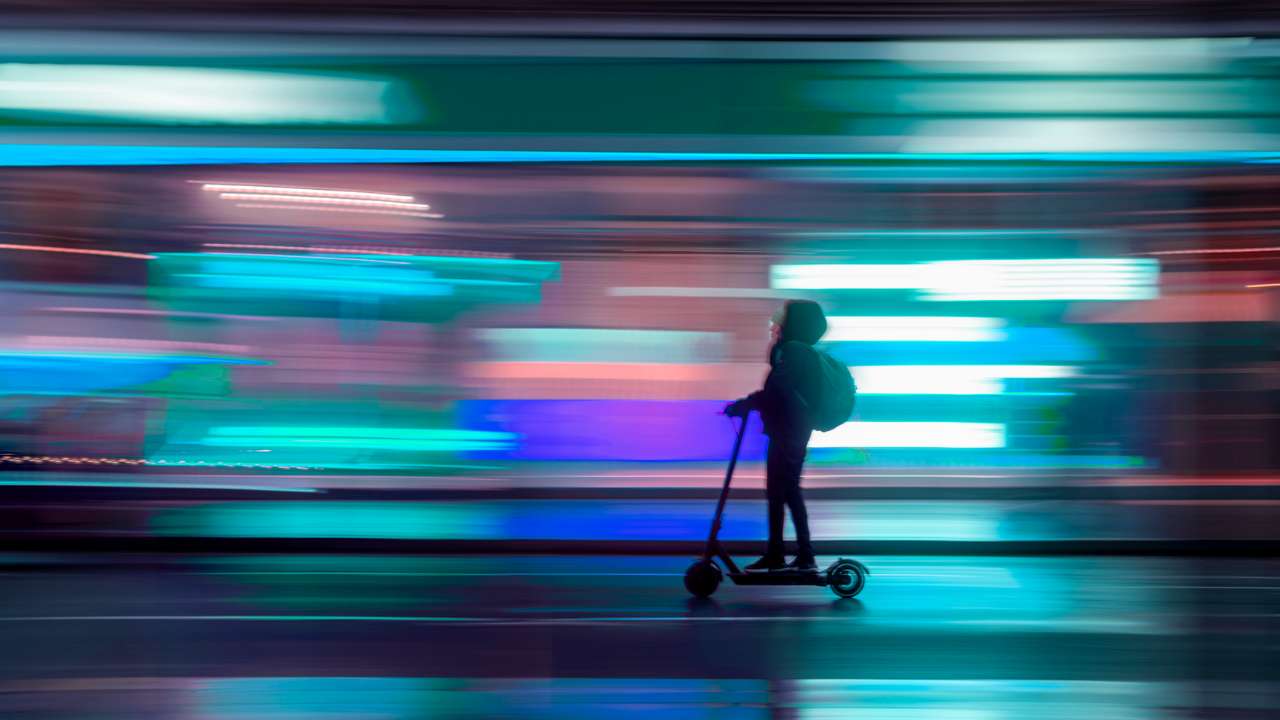 Person on Scooter with colourful blurred background