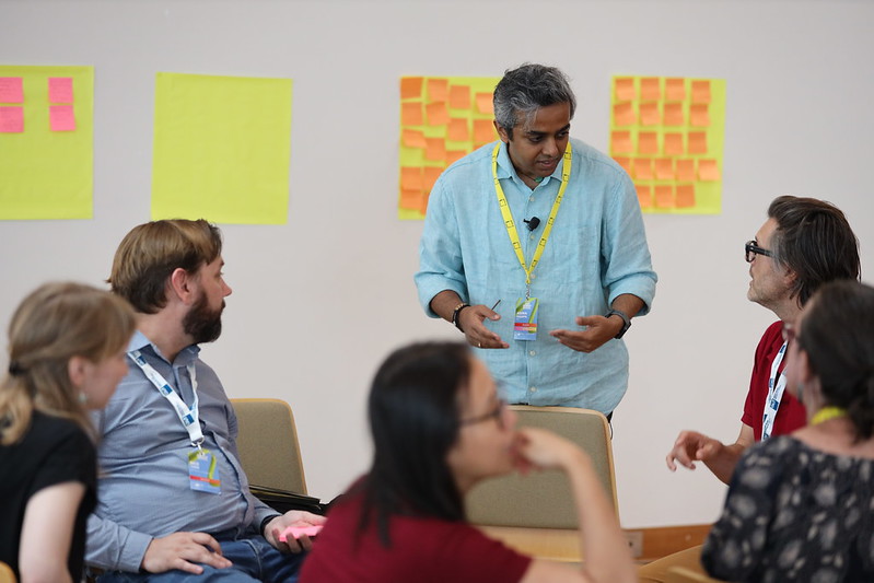 Ashwin Nagappa presenting to colleagues - post it notes on wall in background