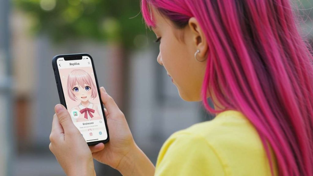 Young girl with pink hair looking at Replika AI companion on mobile phone