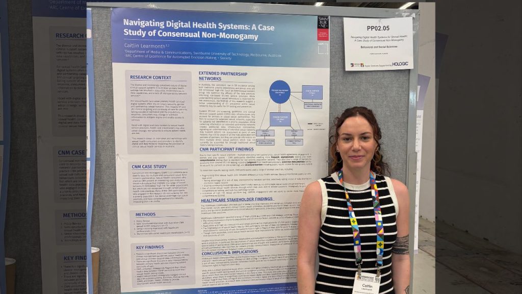 Caitlin Learmonth stands in front of her poster presentation