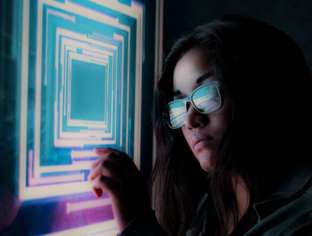 AI systems see the world differently Girl with glasses looking at screen wtih abstract blue and purple image