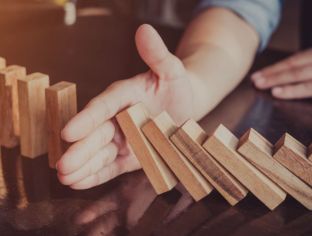 Does AI pose a risk Hand stopping dominoes from falling