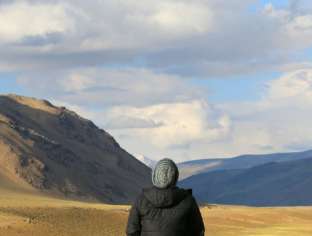 Young people to write AI generated image back of person looking at mountain landscape