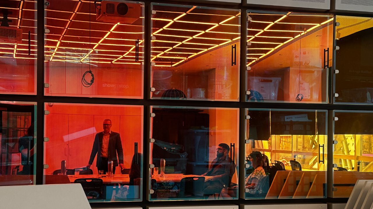 Researchers inside buidling with red and orange glass