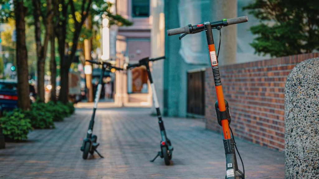 Electric scooters parked on a city sidewalk, embracing urban transportation and modern mobility.