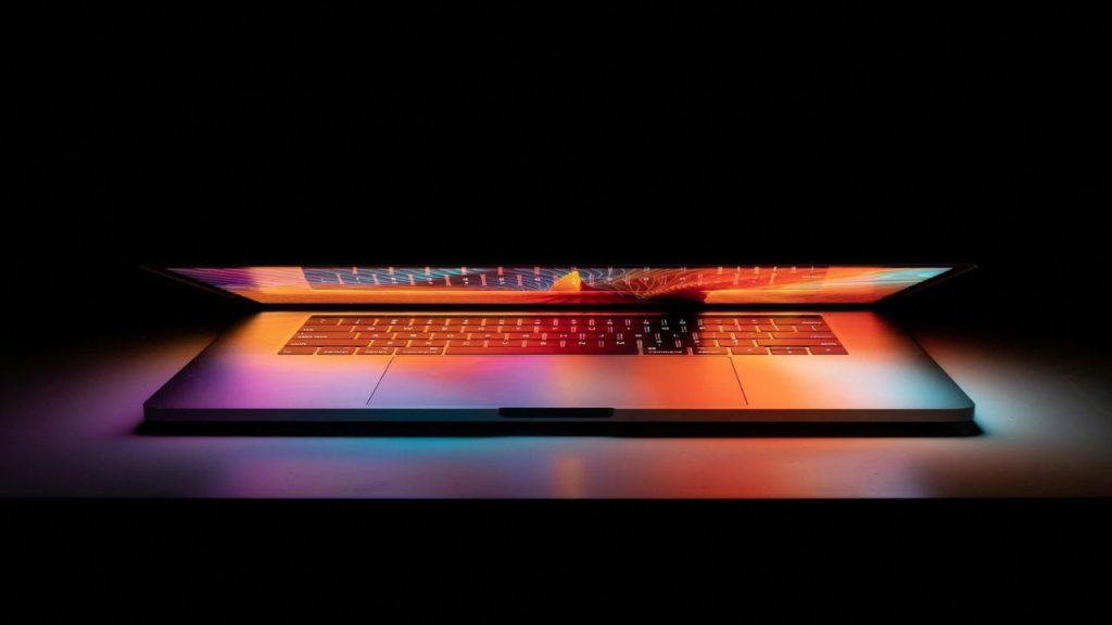 Lapt top half open with purple and orange lighing